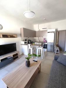 a living room with a table and a kitchen at Athanasia's Place in Ermoupoli