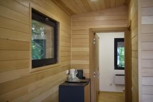 ein Zimmer mit holzgetäfelten Wänden und einem Fernseher an der Wand in der Unterkunft Cetatuia in Măgura