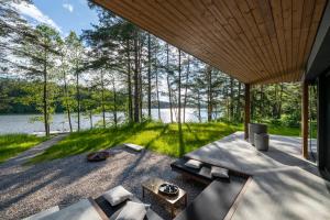 uma vista para a água a partir do alpendre de uma casa no lago em Villa The Lake em Mindūnai