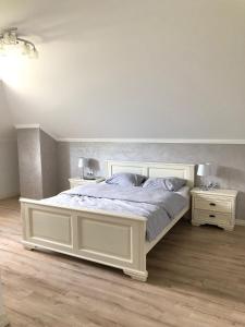 ein Schlafzimmer mit einem weißen Bett und zwei Nachttischen in der Unterkunft Pensiunea Sofia in Telciu