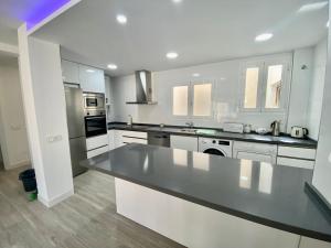 a large white kitchen with a large counter top at Suite Homes Alamos Terrace in Málaga