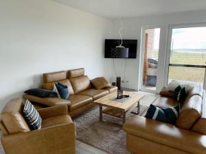 a living room with two couches and a table at Exklusives Apartment mit Blick auf den See in Großräschen