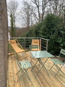 two chairs and a table on a wooden deck at WINNIE Studio indépendant trés proche de DISNEY Paris in Chessy