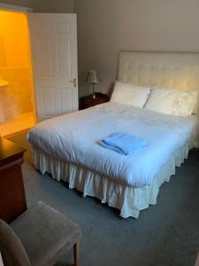 Un dormitorio con una cama blanca con una toalla azul. en Ceol Na Mara, en Westport