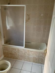 een badkamer met een bad en een toilet bij Ceol Na Mara in Westport