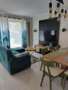 a living room with a blue couch and a table at Domek przy Kasztanowej in Szczyrk