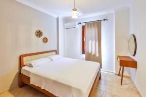 a white bedroom with a bed and a desk at Nirvana Apartments in Kas