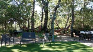 um grupo de cadeiras e mesas num parque com árvores em Casa Rural: La Casa Mágica de Gredos em Madrigal de la Vera
