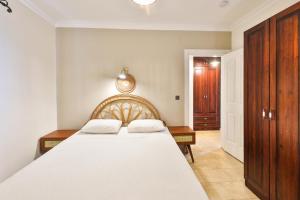 a bedroom with a large white bed and wooden cabinets at Nirvana Apartments in Kas