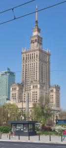 duży budynek z wieżą zegarową na górze w obiekcie Be my Guest - Marszałkowska Studio - Center of Warsaw Subway Wi-Fi Breakfast w Warszawie