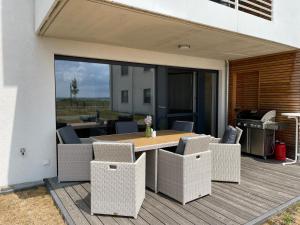 a patio with a table and chairs on a deck at Exklusives Apartment mit Blick auf den See in Großräschen
