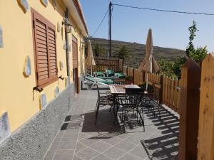 un patio con tavoli, sedie e ombrelloni di Casa Gerian a Vallehermoso