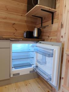 un refrigerador vacío en la cocina de una casa pequeña en Ceide Glamping en Ballycastle