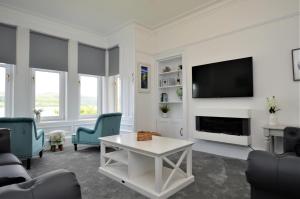 a living room with a fireplace and a tv at Findhorn Upper Apartment in Kames