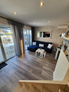Una sala de estar con un sofá azul y una mesa. en SERW, en Władysławowo