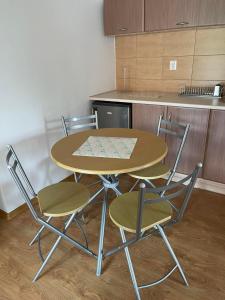 Baltic Trio Apartaments - Rusinowo في ريوزينو: طاولة وأربعة كراسي في مطبخ