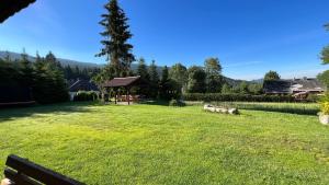 een grote tuin met een tuinhuisje in het gras bij Kubovka 63 in Kubova Huť