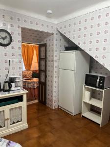 a kitchen with a white refrigerator and a staircase at Casa de la abuela Tere Caminito del Rey, Valle de Abdalajís, Málaga in Valle de Abdalagís