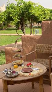 une table en bois avec des assiettes de nourriture dans l'établissement Upupa de l’Atlas, à Marrakech