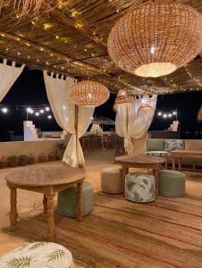 une chambre avec deux tables, des bancs et des lumières dans l'établissement Upupa de l’Atlas, à Marrakech