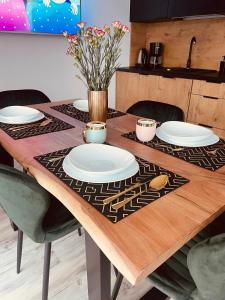 drewniany stół z płytkami i kwiatami w obiekcie Haus am Meer Dziwnówek w Dziwnówku