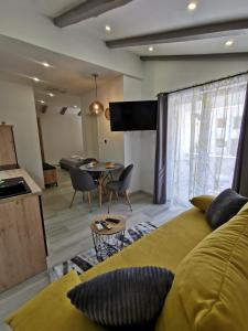 een woonkamer met een bed en een eetkamer bij New Nikolina 4 star in Mali Lošinj
