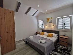 een slaapkamer met een groot bed met gele kussens bij New Nikolina 4 star in Mali Lošinj