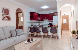 salon z kanapą i kuchnią w obiekcie Apto ACHE, acogedor apartamento de 66 m con terraza, aire acondicionado y parking privado gratuito w mieście Los Abrigos