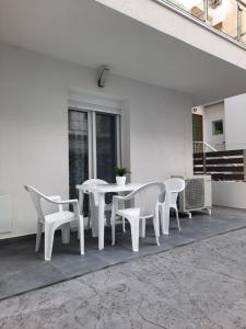 Biały stół i krzesła na patio w obiekcie By the sea w mieście Perea