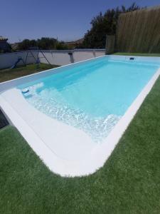 una gran piscina en un patio con césped en MYKONOS entre cepas, en Sanlúcar de Barrameda