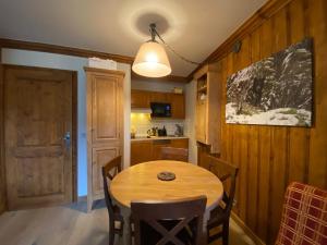 une salle à manger avec une table en bois et une cuisine dans l'établissement Petite Marmotte Spacieux Studio pour 4, Skis aux pieds, Le Refuge du Montagnard, Arc 1950, à Arc 1950