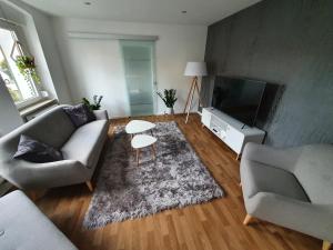 sala de estar con sofá, mesa y TV en Ferienhaus Dani, en Bad Frankenhausen