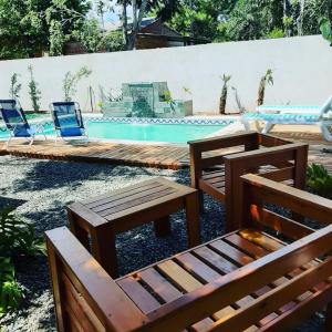 2 sillas y un banco junto a la piscina en Quinta La Encantada en San Ignacio