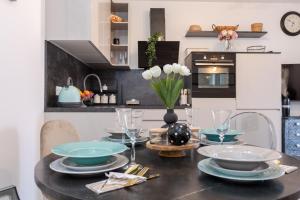 a kitchen with a table with plates and wine glasses at Sangalo apartment in Trogir +37 photos