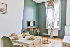 a dining room with a white table and chairs at VILLA VERDE #Hypercentre #Charente #Parking in Cognac