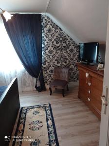 Zimmer mit einer Treppe, einem TV und einem blauen Vorhang in der Unterkunft La Gravière 