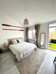 ein Schlafzimmer mit einem großen weißen Bett mit einem Teppich in der Unterkunft Parenthèse insulaire in LʼÉpine