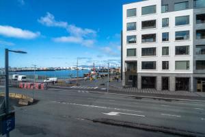 una calle vacía junto a un gran edificio blanco en Ocean Breeze Luxury Apartment, en Reikiavik