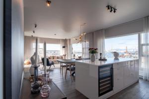 a kitchen and dining room with a view of a city at Ocean Breeze Luxury Apartment in Reykjavík