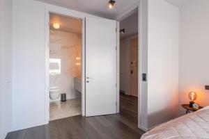 1 dormitorio con puerta que conduce a un baño en Ocean Breeze Luxury Apartment, en Reikiavik