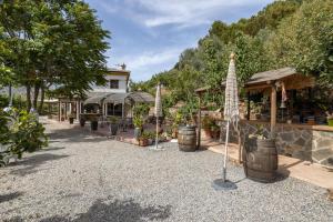 a garden with plants in barrels and a building at Villa Malaga con Jacuzzi Piscina vallada Barbacoa By AndaraHolidays in Sayalonga