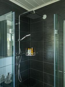 a bathroom with a shower with a glass door at The Novac's Cottage in Råneå