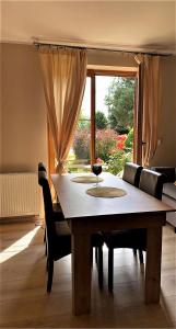uma mesa e cadeiras numa sala de estar com uma janela em Uroczy dom Wszebory 