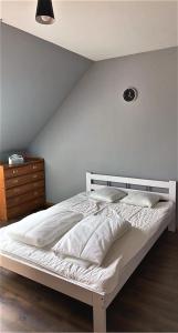 a white bed in a bedroom with a wall at Uroczy dom Wszebory 