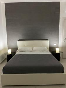 - une chambre avec un grand lit et 2 tables dans l'établissement GLAM B&B room, à San Giuseppe Vesuviano