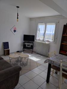 uma sala de estar com um sofá e uma mesa em Appartement Abadie em Bagnères-de-Bigorre