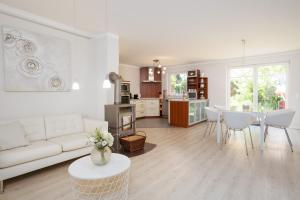 een woonkamer met een witte bank en een tafel bij Haus Sommerzeit 