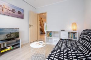 a living room with a couch and a television at Haus Sommerzeit 