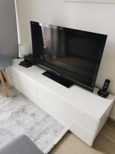 a flat screen tv sitting on a white entertainment center at Chic&Chic in Szczecin