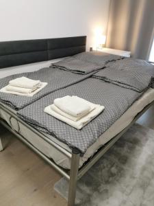 a bed with two white towels on top of it at Chic&Chic in Szczecin
